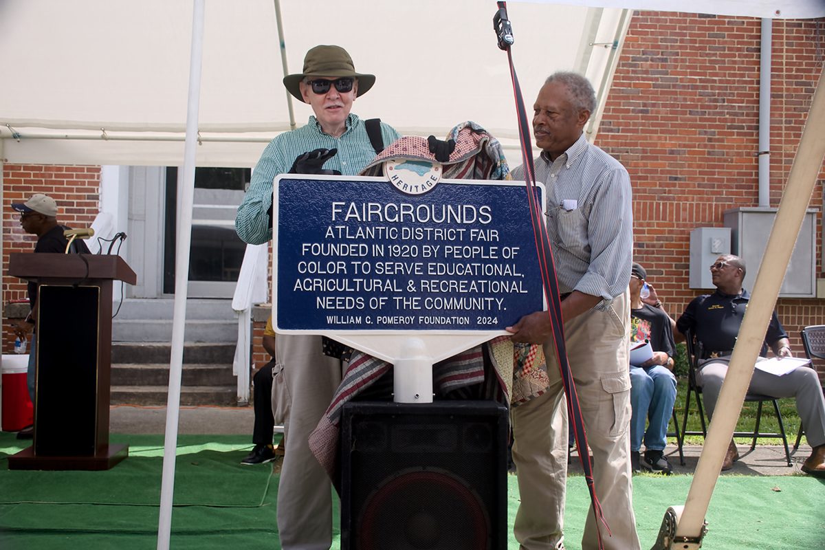 Chowan Discovery Group Executive Director Marvin Jones, left, and Atlantic District Fair Association Chairman James Peele unveil the marker, yet to be erected, June 14 at the R.L. Vann School at 415 Holloman Ave. in Ahoskie. Photo: Kip Tabb