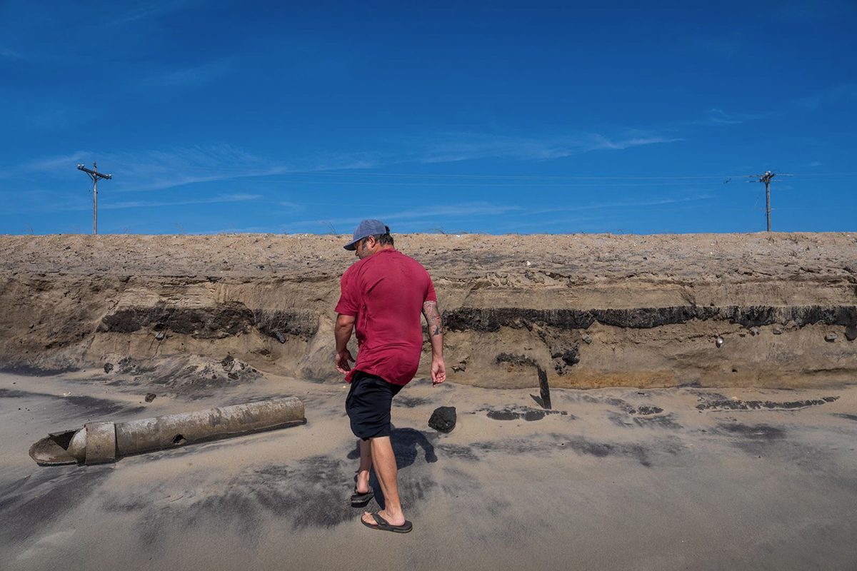 Brian Harris of the Buxton Civic Association walks around exposed debris earlier this week at Buxton Beach. Photo: Daniel Pullen