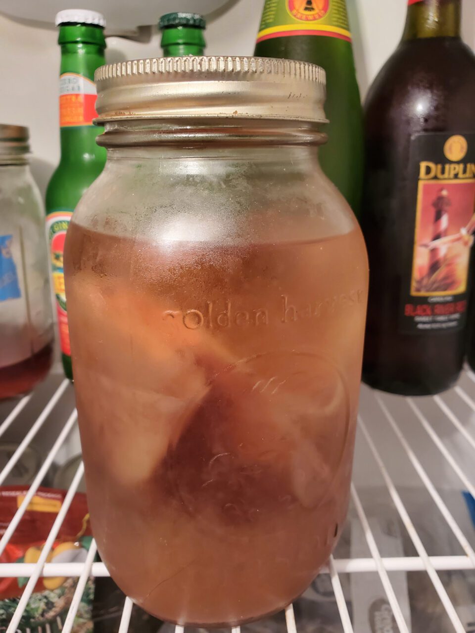 Looking like pickled pig's feet, a SCOBY, or symbiotic culture of bacteria and yeast, does its fermentation thing while a bottle of Duplin County's finest fermented beverage photobombs. Photo: Andrew Smith