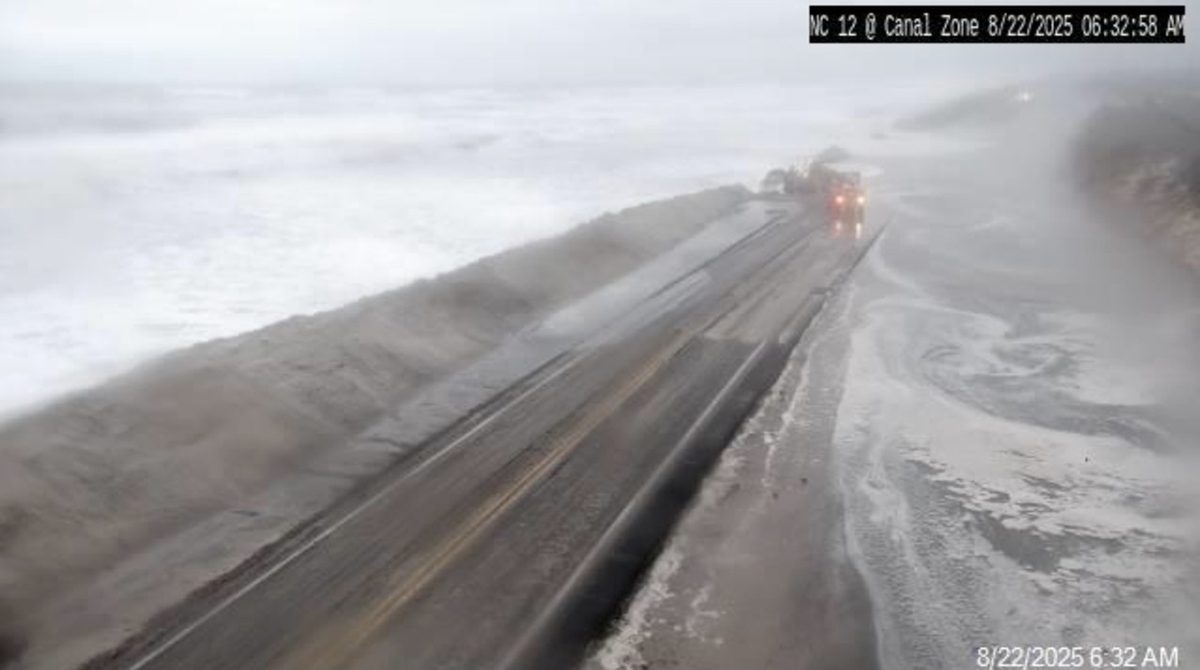 Oceanwater floods N.C. Highway 12 Friday morning at the Canal Zone just south of Oregon Inlet, one of two dune breaches opened by Hurricane Erin. Photo: NCDOT