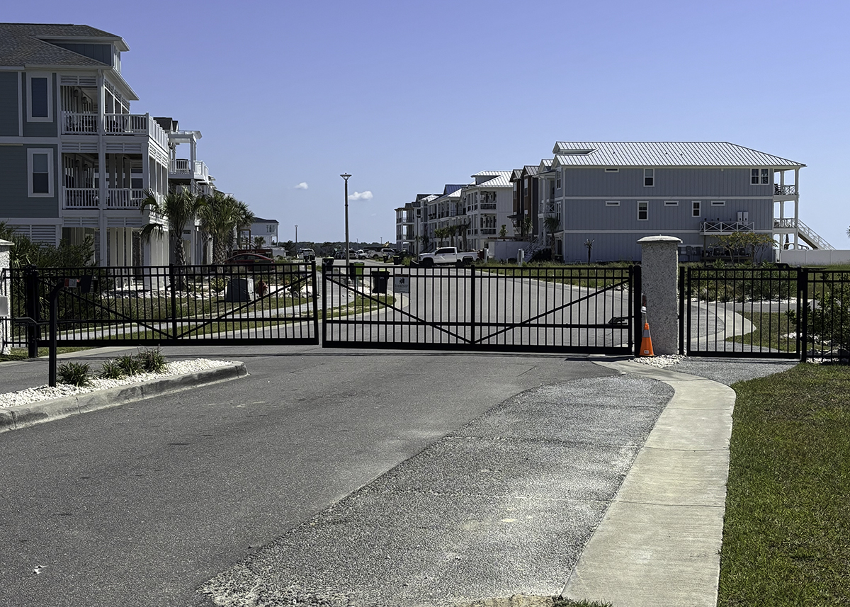 Rows of new houses stretch along a privately owned road past the entrance gate to The Pointe, a neighborhood built at the eastern point of Ocean Isle Beach. Photo: Trista Talton