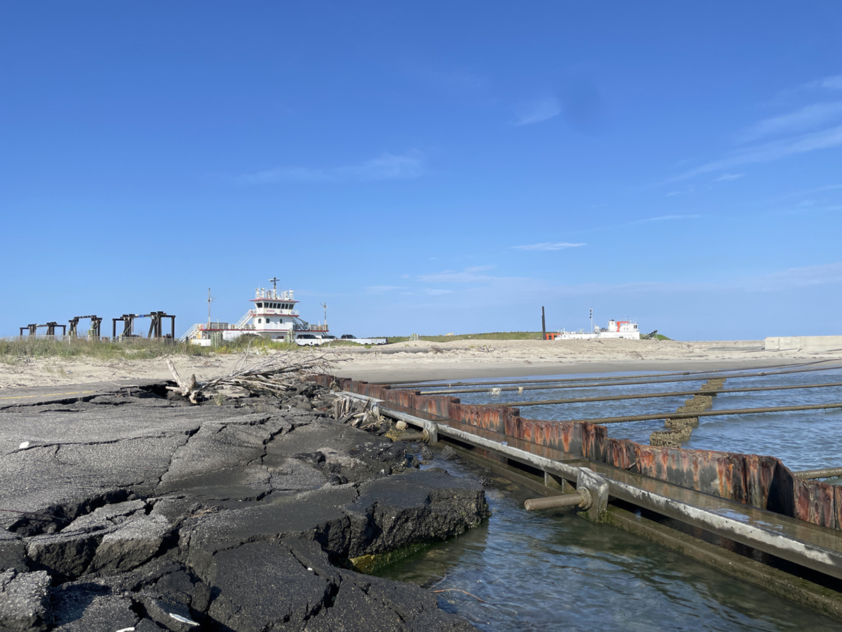 State Ferry Division vessels can be seen beyond the crumpled asphalt and a deteriorated sheet-pile jetty at the ferry terminal that serves as the connection between Ocracoke and Hatteras Island. Photo: Michael Flynn/National Park Service
