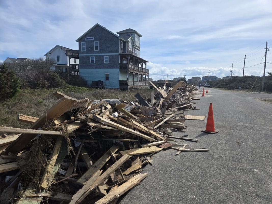 Debris lines the street Sunday following the collapse of nine oceanfront homes last week in Buxton and Rodanthe. Photo: Don Bowers