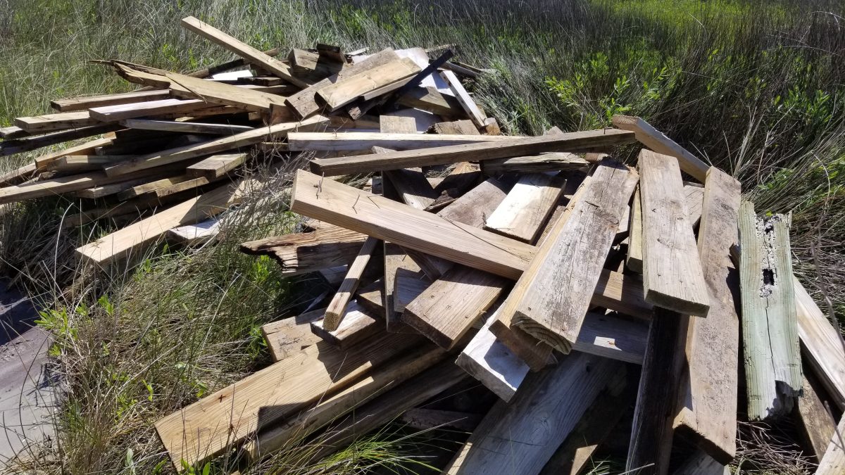 Planks from destroyed docks are piled up on a marsh after a storm in this North Carolina Coastal Federation photo.