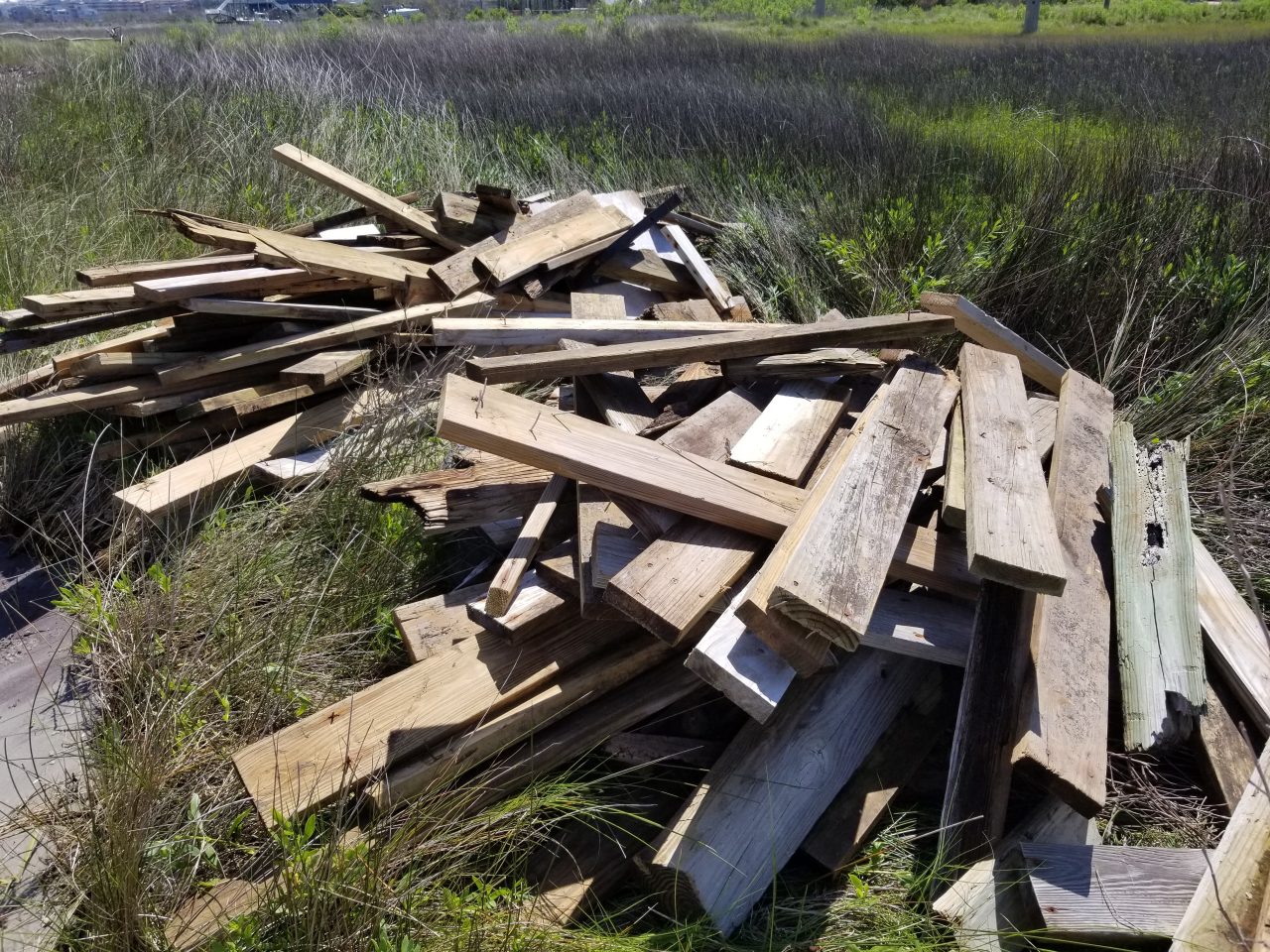 Planks from destroyed docks are piled up on a marsh after a storm in this North Carolina Coastal Federation photo.