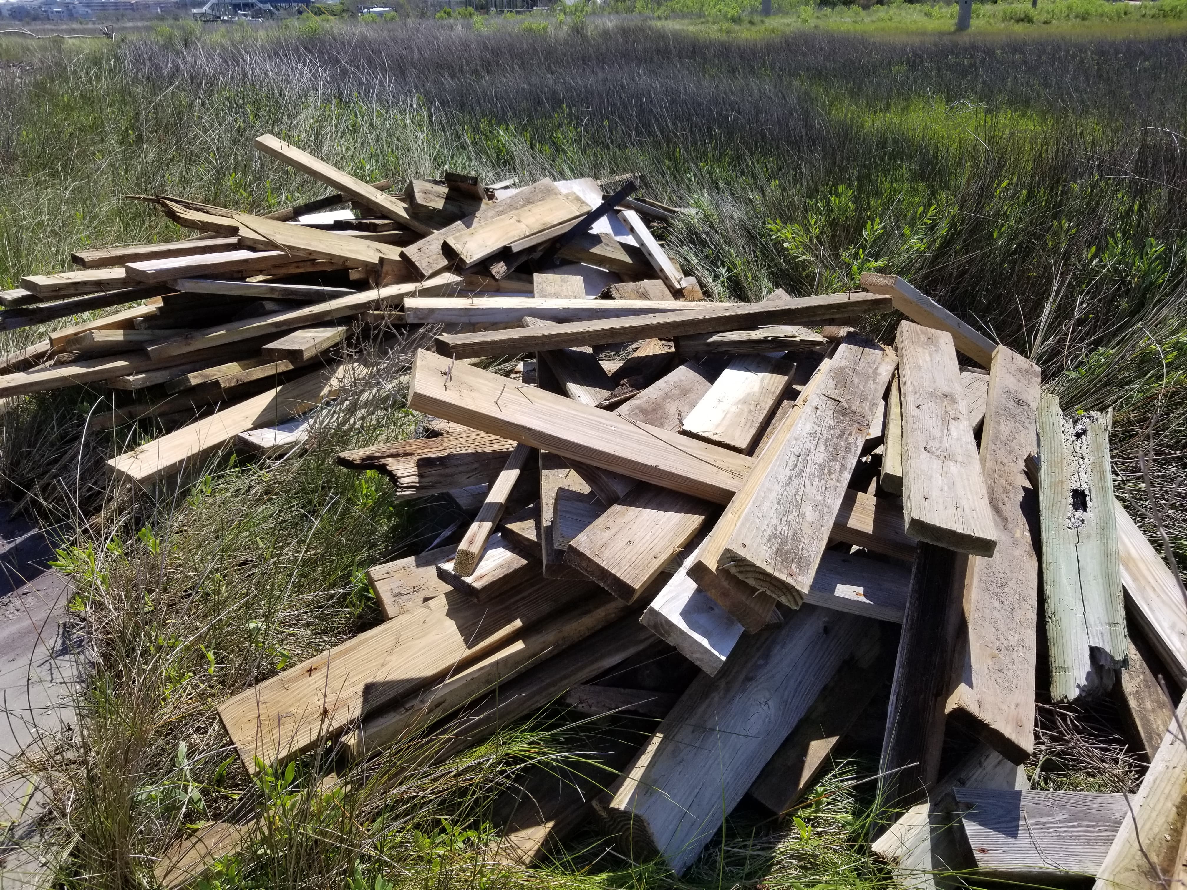 Planks from destroyed docks are piled up on a marsh after a storm in this North Carolina Coastal Federation photo.