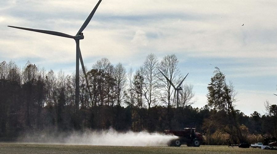 Farm equipment operates in rural Chowan County with Timbermill Wind turbines just beyond. Photo: Catherine Kozak