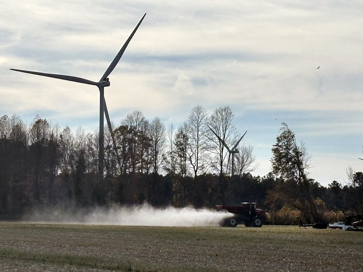 Farm equipment operates in rural Chowan County with Timbermill Wind turbines just beyond. Photo: Catherine Kozak
