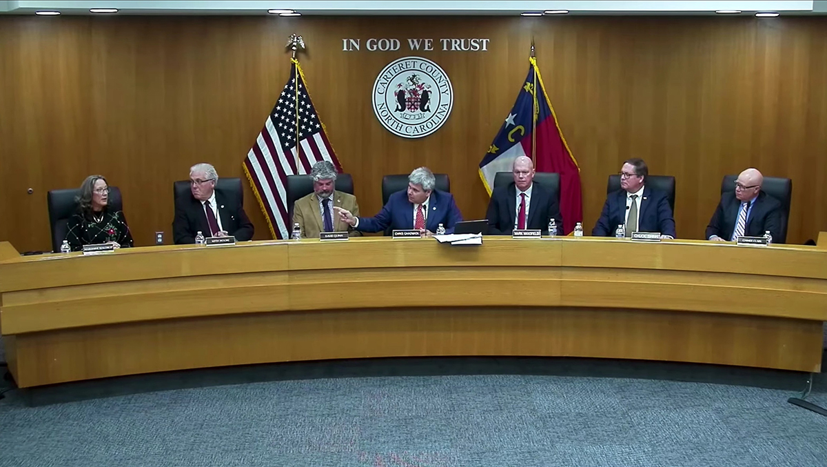 Carteret County Board of Commissioners Chairman Chris Chadwick points his finger toward Commissioner Marianne Waldrop Monday during an exchange between the two regarding holiday wishes in this screenshot from the official county video of the commissioners meeting in Beaufort.