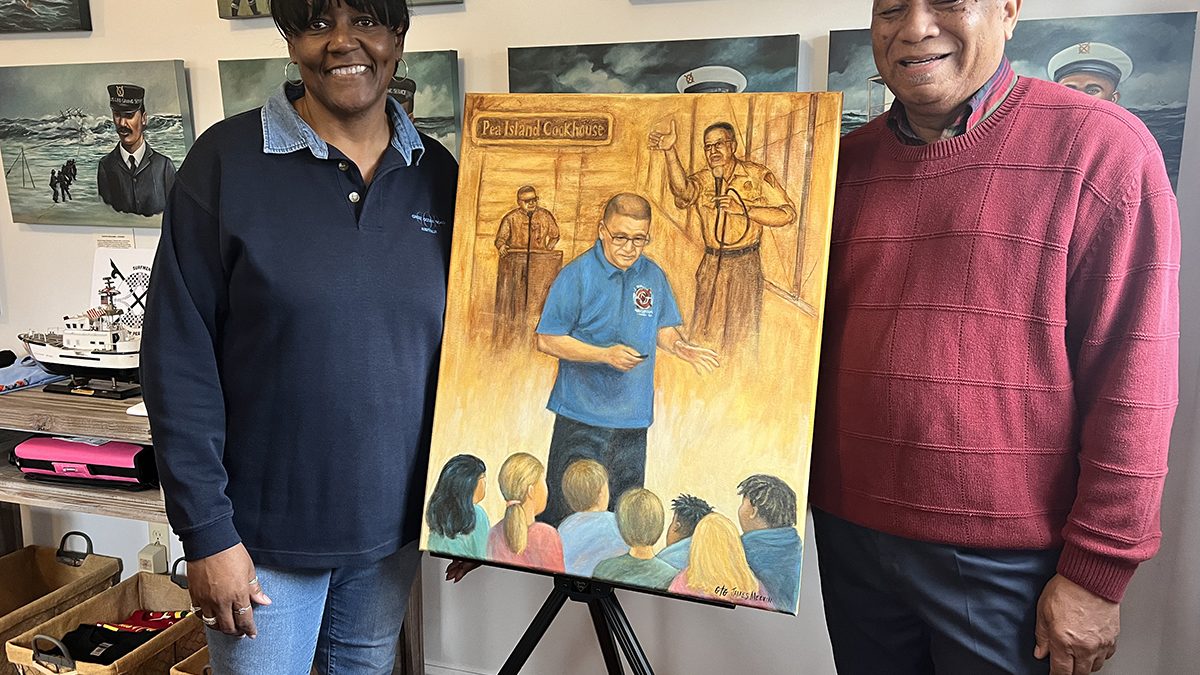 Tonya Collins, left, the late Darrell Collins' wife, accepts the portrait of her husband entitled “A Legacy of Greatness” and painted by James Melvin, as the artist delivers the gift at the Pea Island Cookhouse Museum in Manteo. Photo: Pea Island Preservation Society Inc.