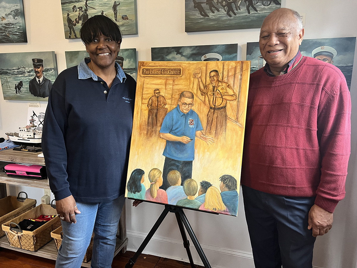 Tonya Collins, left, the late Darrell Collins' wife, accepts the portrait of her husband entitled “A Legacy of Greatness” and painted by James Melvin, as the artist delivers the gift at the Pea Island Cookhouse Museum in Manteo. Photo: Pea Island Preservation Society Inc.