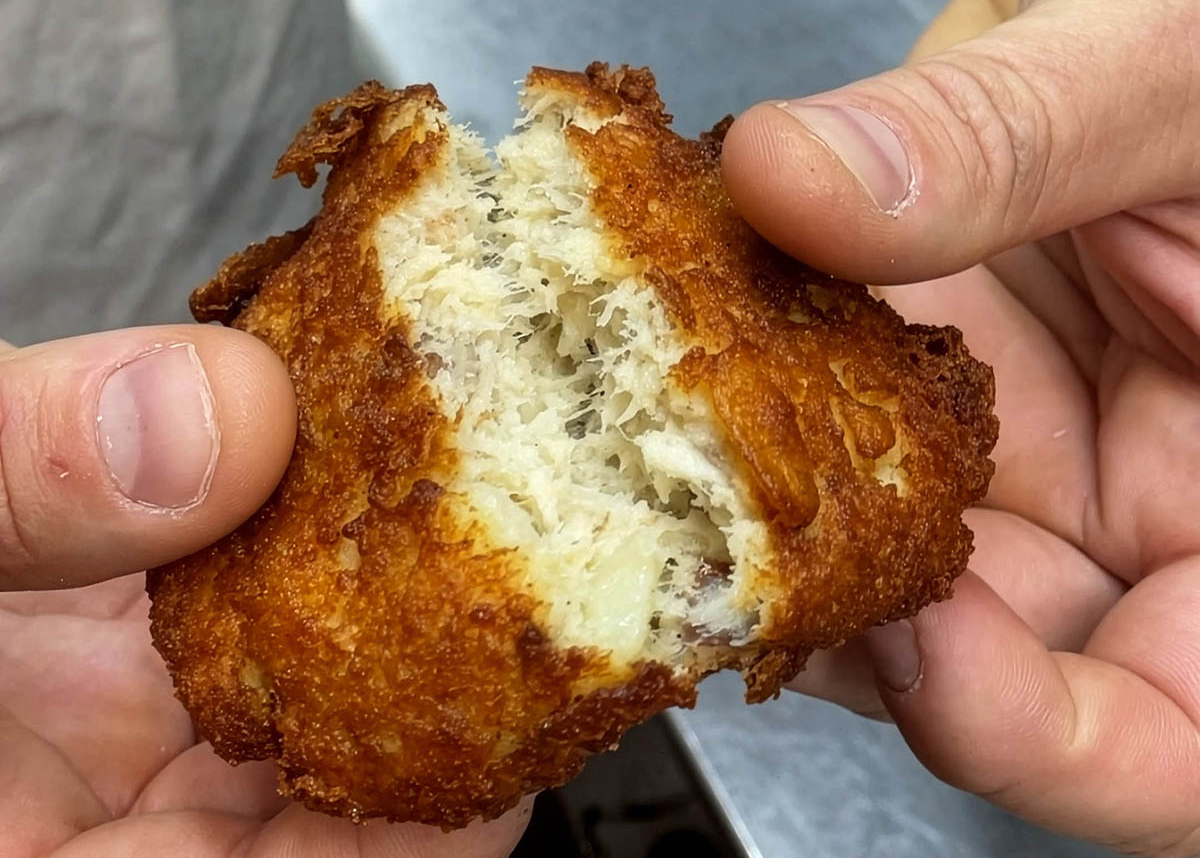 Sharon Peele Kennedy’s son, Jeffrey Kennedy, reveals flaked white fish mingled with mashed potatoes in a pillowy yet crisp fish cake at Basnight’s Lone Cedar Café in Nags Head. Photo: Liz Biro