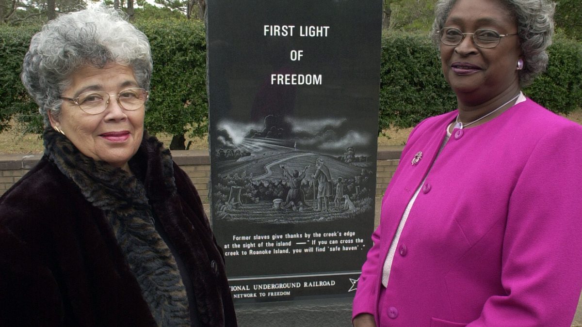 Former Manteo Commissioner Dellerva Collins, left, now deceased and whose vision was to open the Pea Island Cookhouse Museum poses with former Dare County Commissioner Virginia Tillett, also now deceased, at the First Light of Freedom Memorial unveiling in 2001. “Dell” as Collins was best known, played a key role resulting in the placement of this memorial at the National Park Service - Fort Raleigh site. Because of  her leadership, in 2006 the original cookhouse building once located at the Pea Island station was moved to Roanoke Island and renovated as a museum. Photo: Drew Wilson