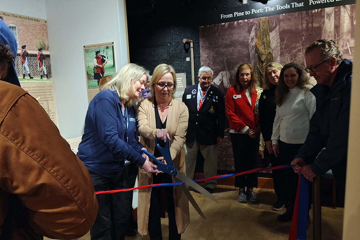 Brenda Cummins of the nonprofit Eastern National and a representative of the Wilmington Ladies Tea Walk Chapter of the National Society of the Daughters of the Revolution cut the ceremonial ribbon for two new exhibits at the Moores Creek National Battlefield visitor center. Photo: Jennifer Allen