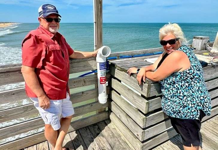 David Masters Jr., vice president of the Outer Banks Anglers Club, and Debbie Swick, a local environmental advocate and club member, are leading the club’s effort to recover and recycle monofilament fishing line. Here, they pose with a newly installed vessel at Avalon Pier. Photo: Brian Tress