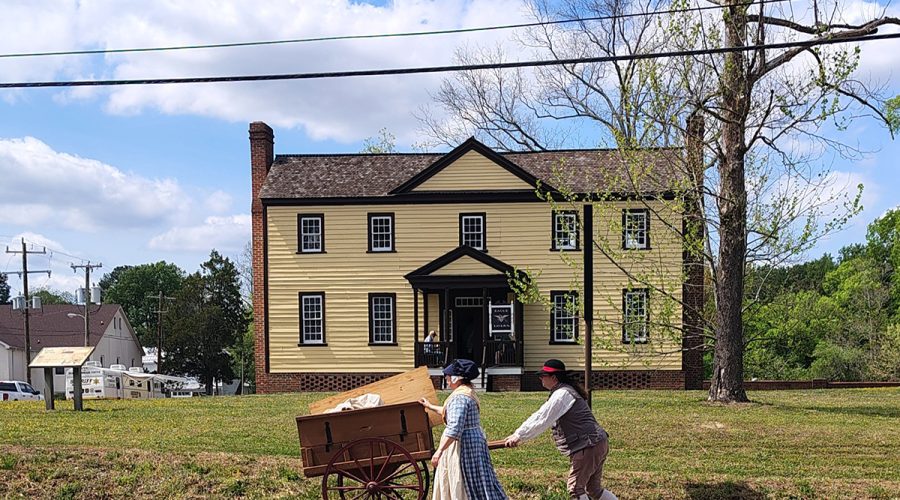 Reenactors walk by Eagle Tavern, a historic building on the grounds of Historic Halifax State Historic Site Sunday during the 250th anniversary commemoration of the Halifax Resolves. Photo: Jennifer Allen