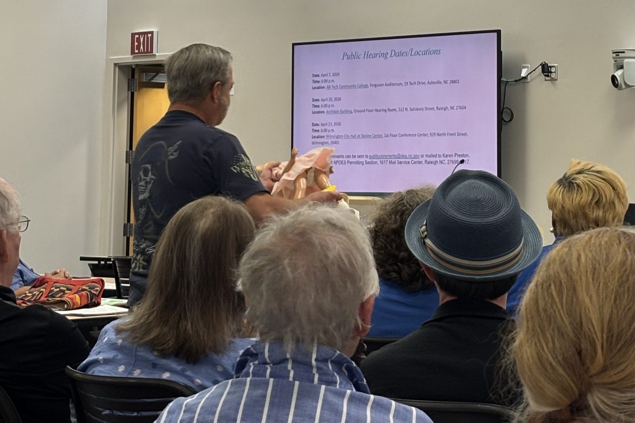  New Hanover County resident Chip Jackson uses a doll baby at the podium to make his point Thursday at the Environmental Management Commission hearing in Wilmington. Photo: Trista Talton