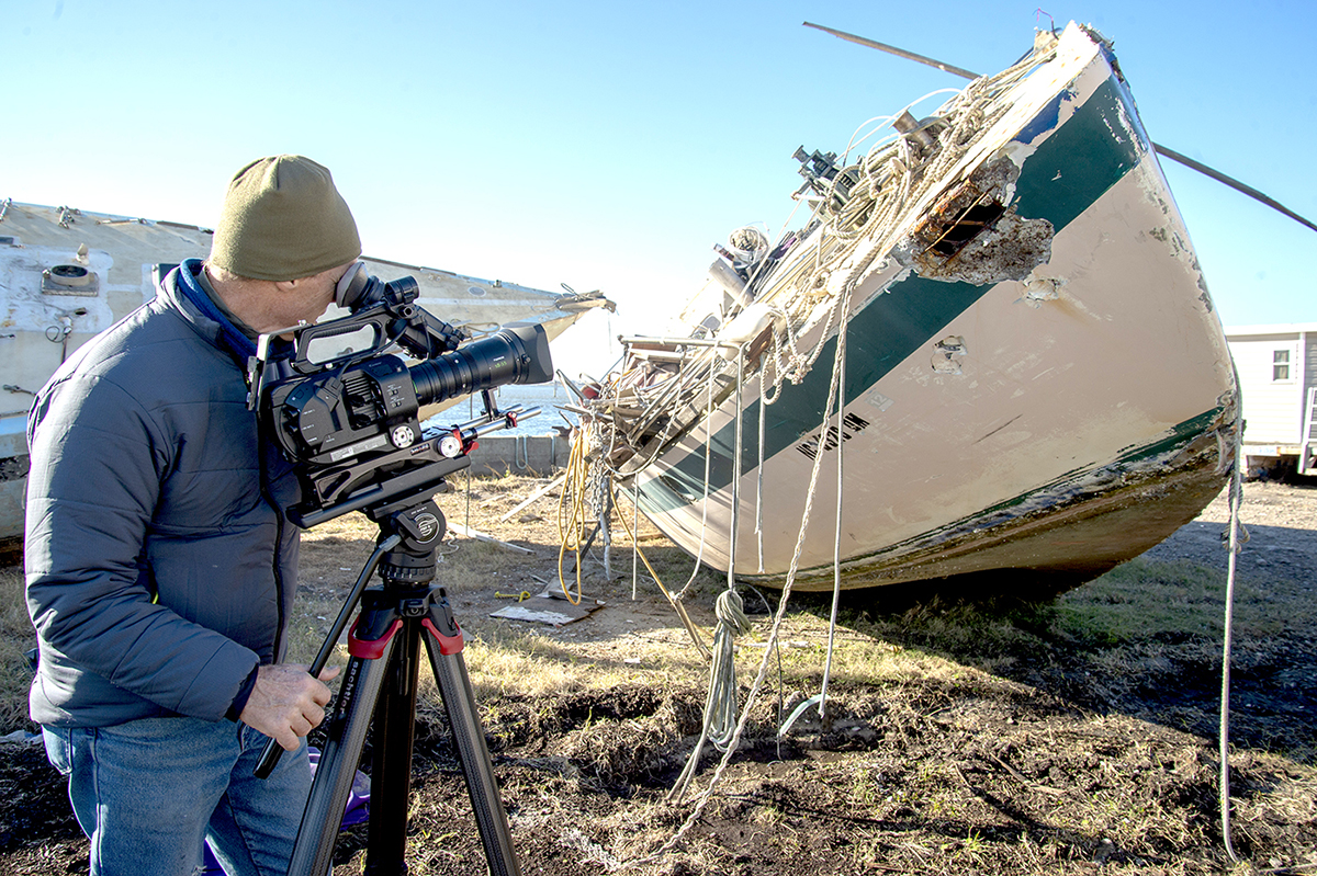 Videographer Paul Cronin shoots footage of the derelict concrete sailboats on the TowBoatUS lot awaiting transfer to the landfill in 2018. BoatUS Foundation was awarded a federal grant to remove derelict vessels and fishing nets from Beaufort Harbor. Photo: NOAA
