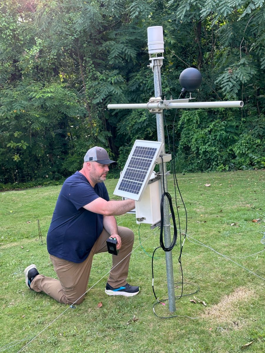 Jared Bowden works with a weather instrument station. 