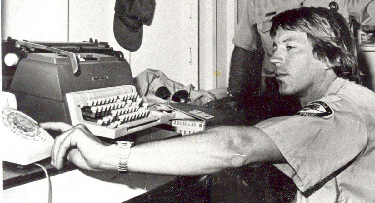 Ranger In Charge George Barnes reaches for the phone in the park's storage shed office during its earliest days.