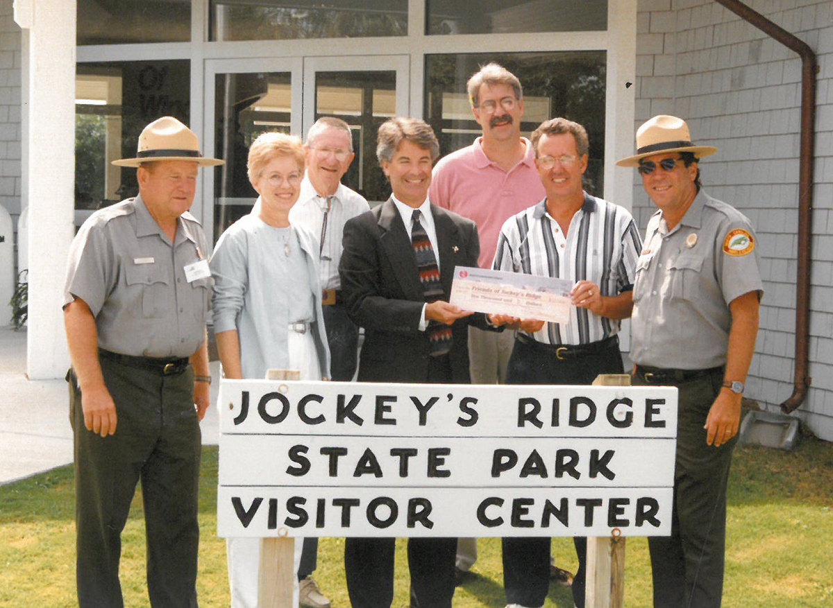 Superintendent George Barnes, far right, poses with North Carolina State Parks District Superintendent Cliff Phillips, far left, members of the nonprofit Friends of Jockeys Ridge State Park during a check presentation.