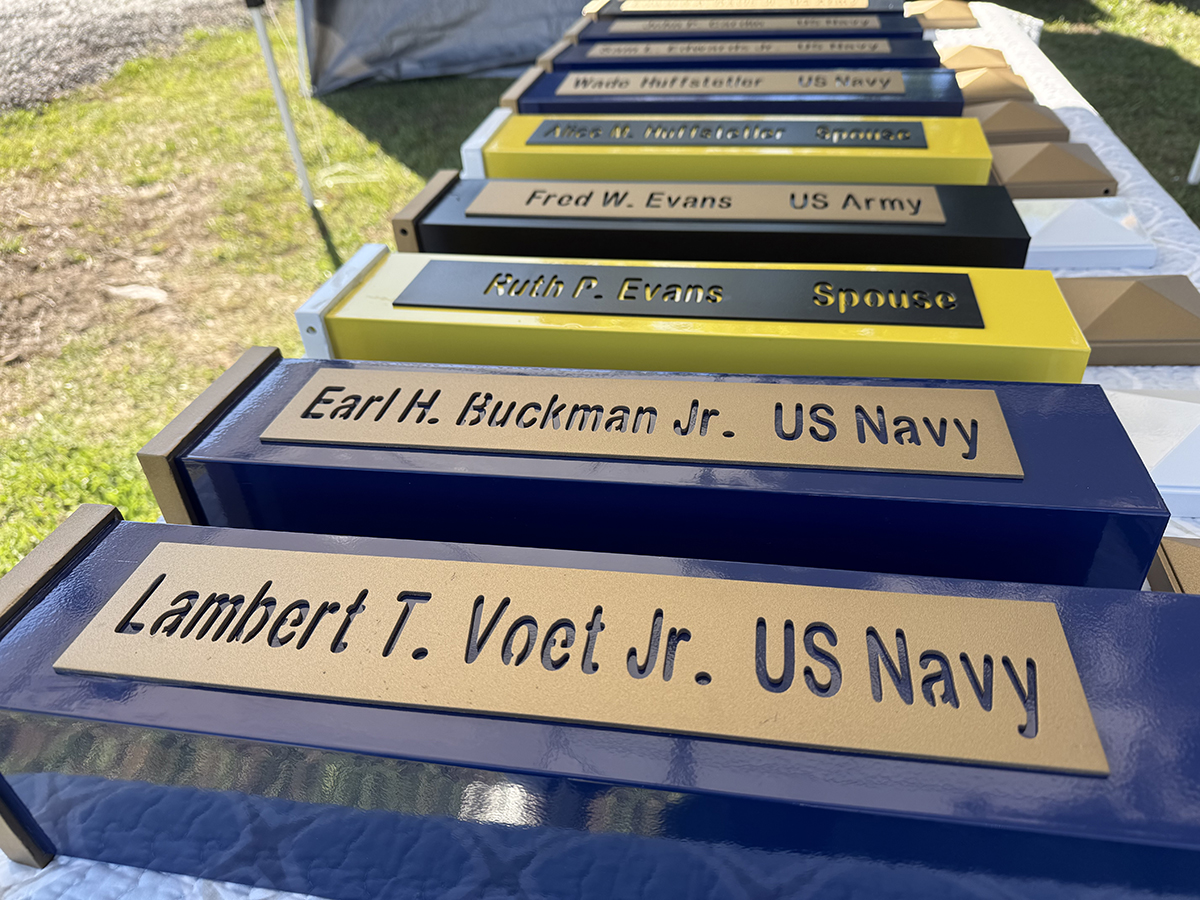 Nameplates honoring six veterans and three veteran spouses are lined up Friday on a table for the Veterans Memorial Reef Ceremony at the Fort Johnston Museum and Visitor Center in Southport. Photo: Vivian Yuditsky