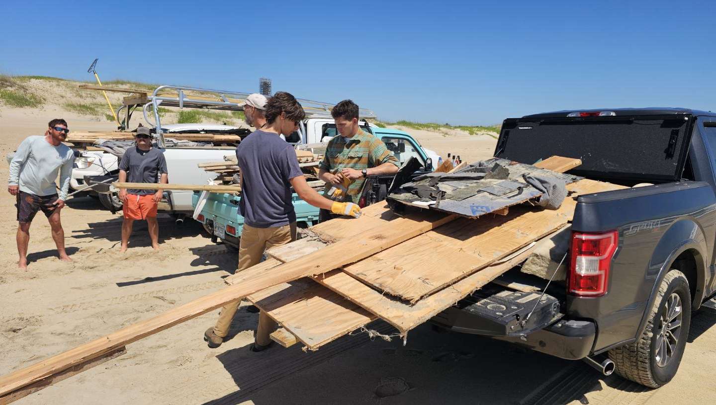Volunteers on Wednesday load debris from the collapsed house into the bed of a pickup truck. Photo:Dan Rothermel