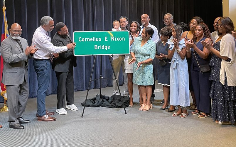 Nixon family members and representatives of the N.C. Department of Transportation and the Nixon Leadership Center at Cape Fear Community College in Wilmington unveil the Cornelius E. Nixon Bridge sign slated for the Military Cutoff Overpass above Market Street during a dedication ceremony April 24 at Cape Fear Community College. Photo: Liz Biro