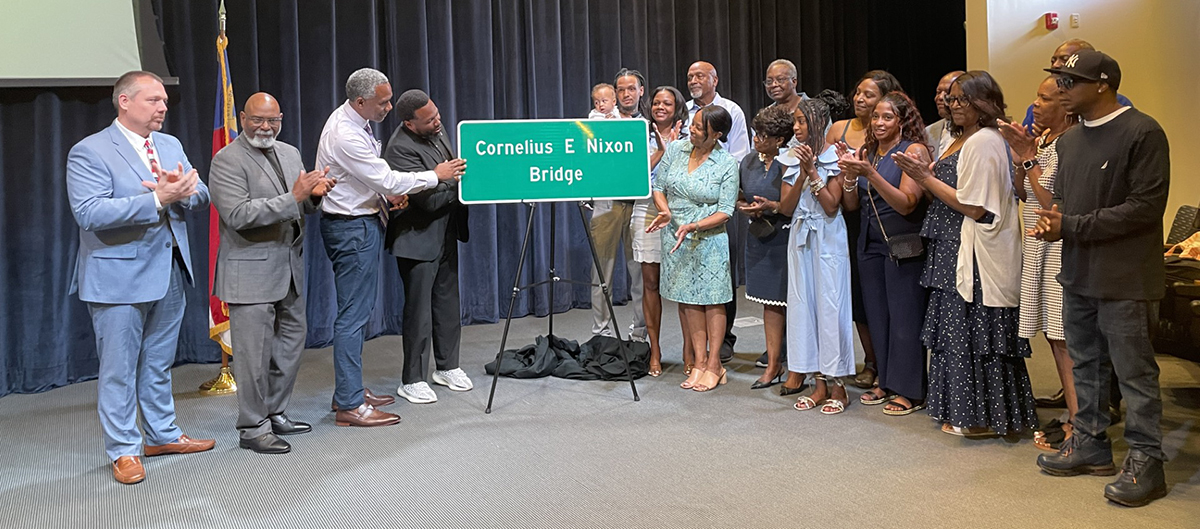 Nixon family members and representatives of the N.C. Department of Transportation and the Nixon Leadership Center at Cape Fear Community College in Wilmington unveil the Cornelius E. Nixon Bridge sign slated for the Military Cutoff Overpass above Market Street during a dedication ceremony April 24 at Cape Fear Community College. Photo: Liz Biro