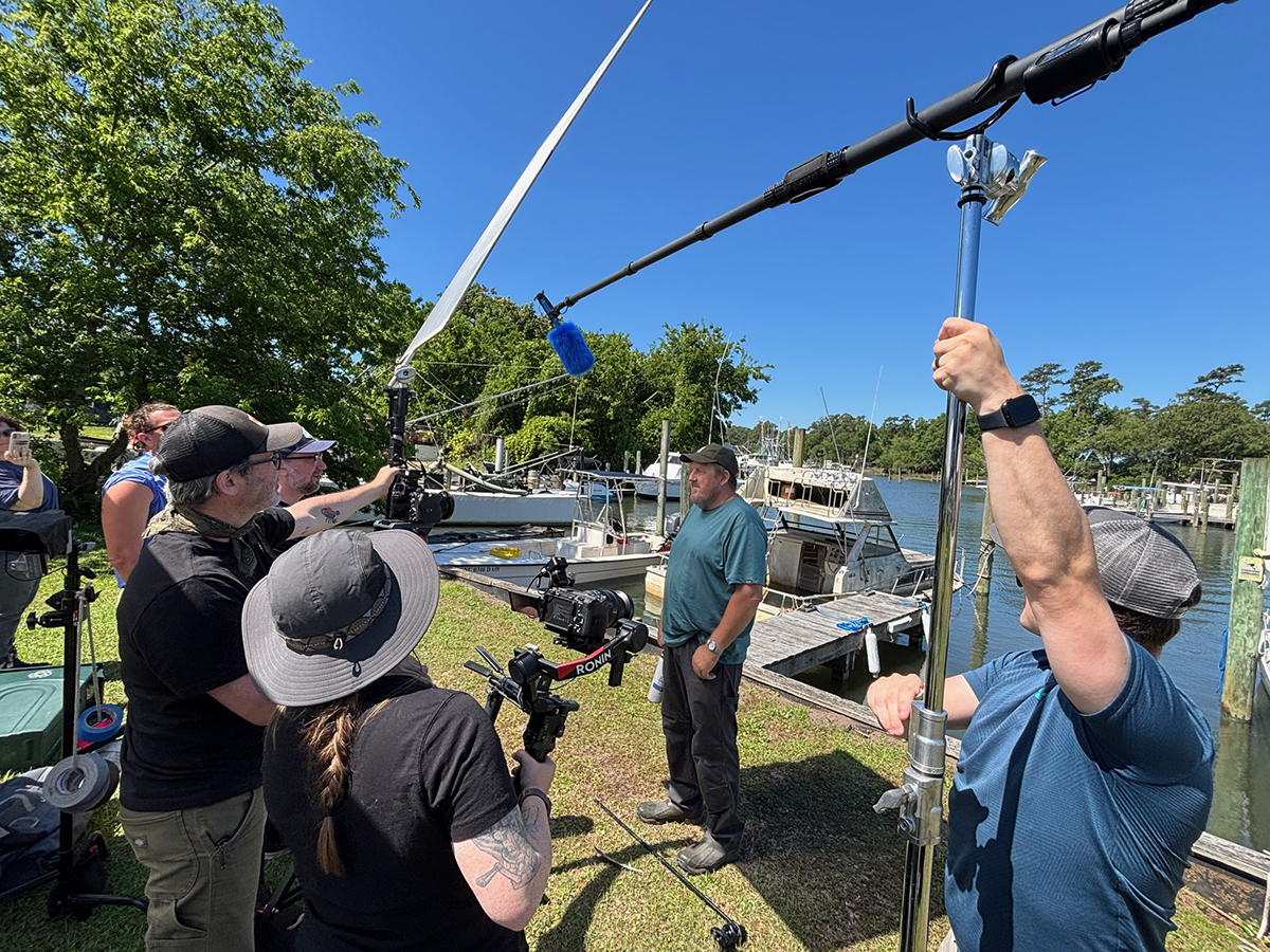 A documentary crew for BoatUS Foundation interview Ted Wilgis (center), the North Carolina Coastal Federation's marine debris removal program manager, at Wheeler Creek in Sneads Ferry on Wednesday. Photo: Trista Talton