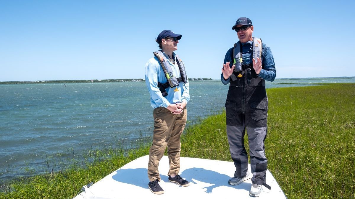 UNC Chancellor Lee H. Roberts, left, listens as IMS Director Dr. Joel Fodrie,gives an overview of the coastal ecosystems in the area. Photo: Jon Gardiner/UNC-Chapel Hill