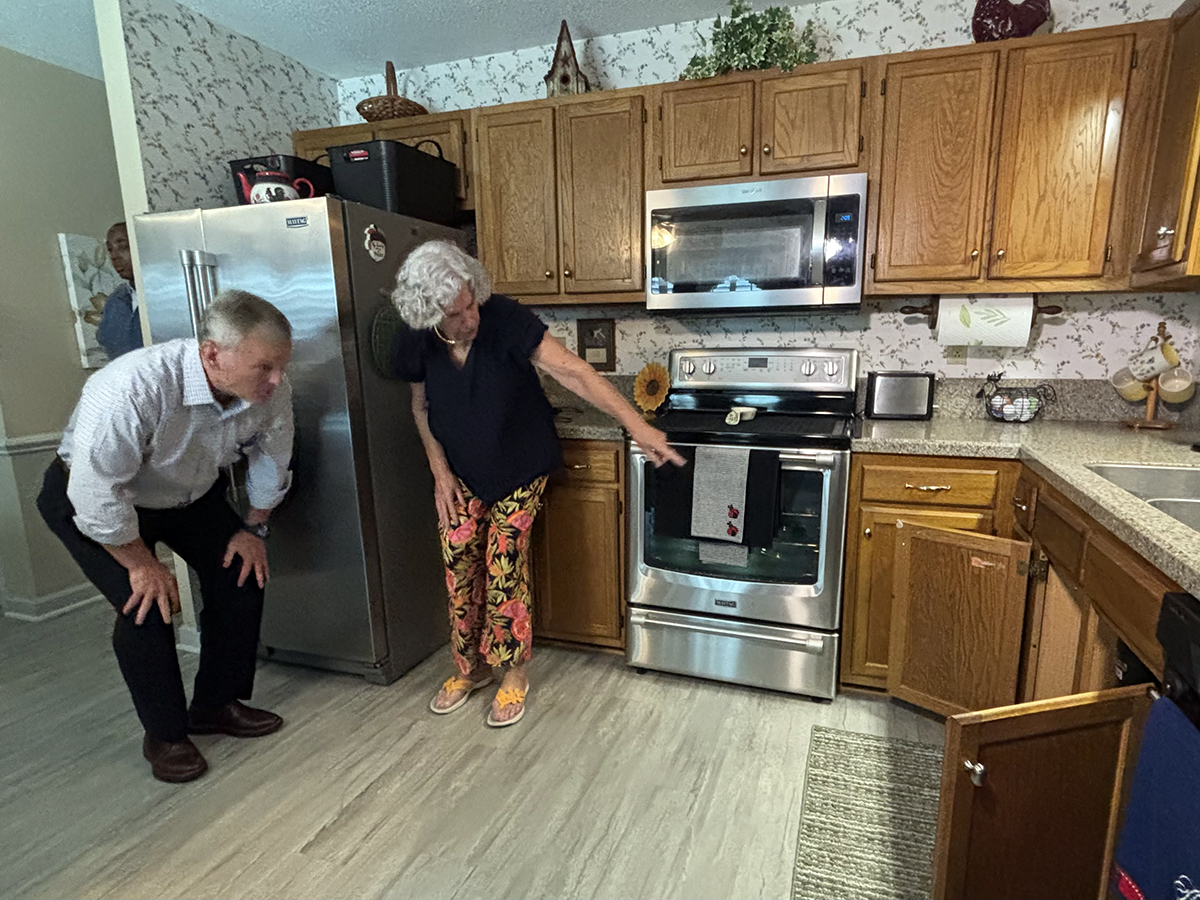 North Carolina Gov. Josh Stein looks on as Brenda Moore points to a reverse osmosis water filtration system under the kitchen sink of her family's Wilmington-area home on Wednesday. Photo: Trista Talton