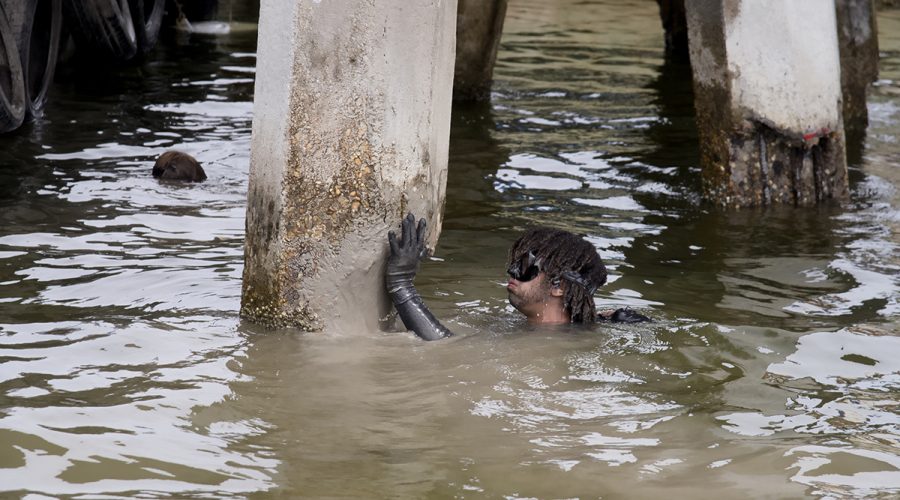 Diver Roman Morgan applies quick-setting mortar by hand, the final step in this method of repairing damaged bridge pilings. Photo: Kip Tabb