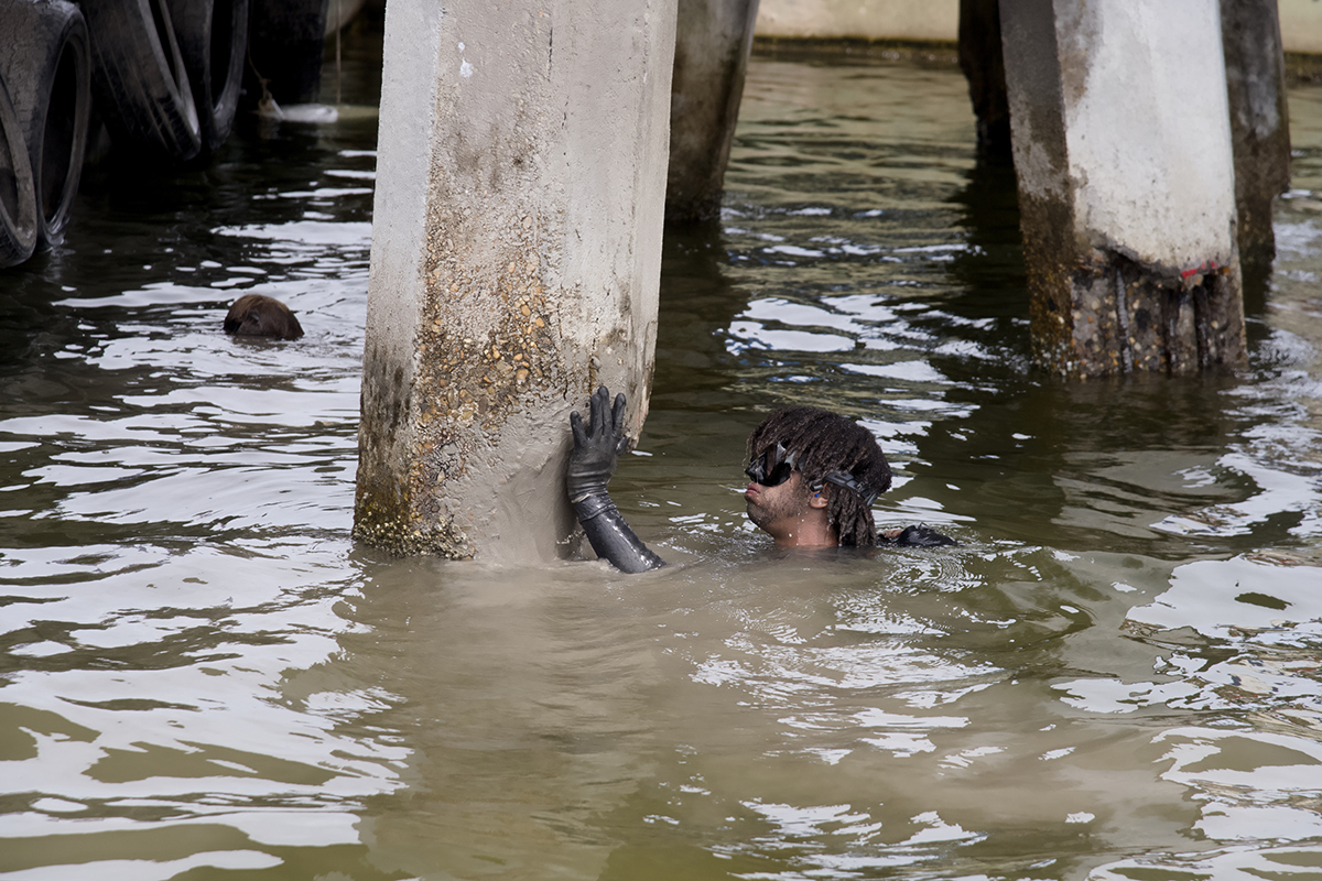 Diver Roman Morgan applies quick-setting mortar by hand, the final step in this method of repairing damaged bridge pilings. Photo: Kip Tabb