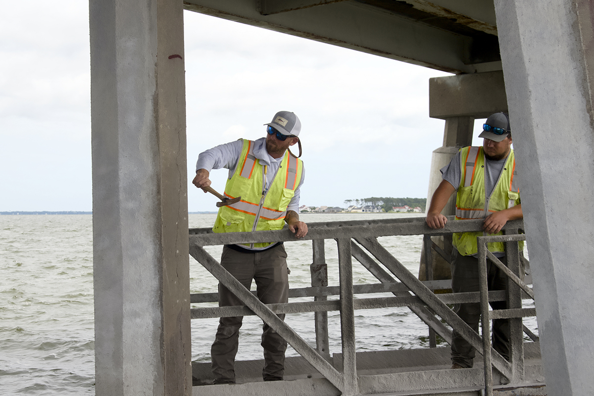Kevin Brown and Adam Conner with the bridge crew evaluate a piling for spalled and deteriorated concrete. Photo: Kip Tabb