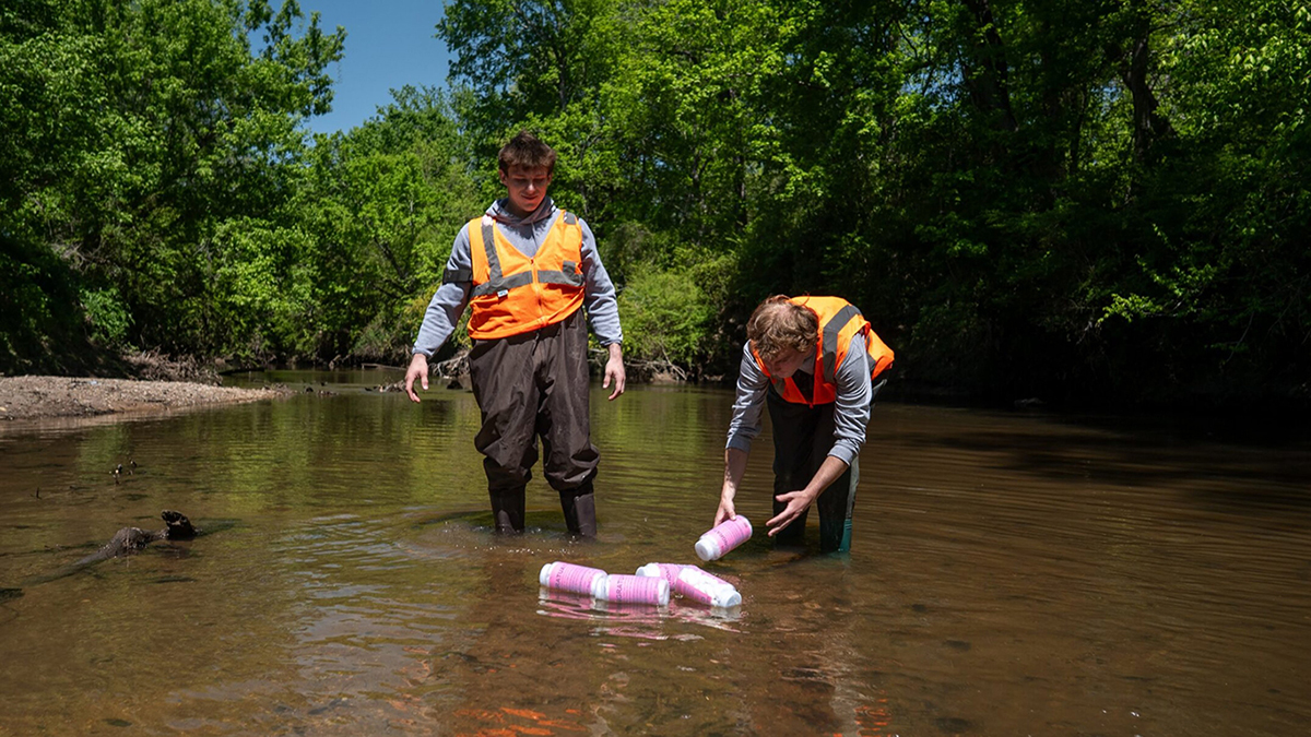 Working in a freshwater stream, researchers deploy trackable bottles that may -- or may not -- carry them to the Neuse River, into Pamlico Sound and eventually the Atlantic Ocean. Photo: North Carolina Sea Grant