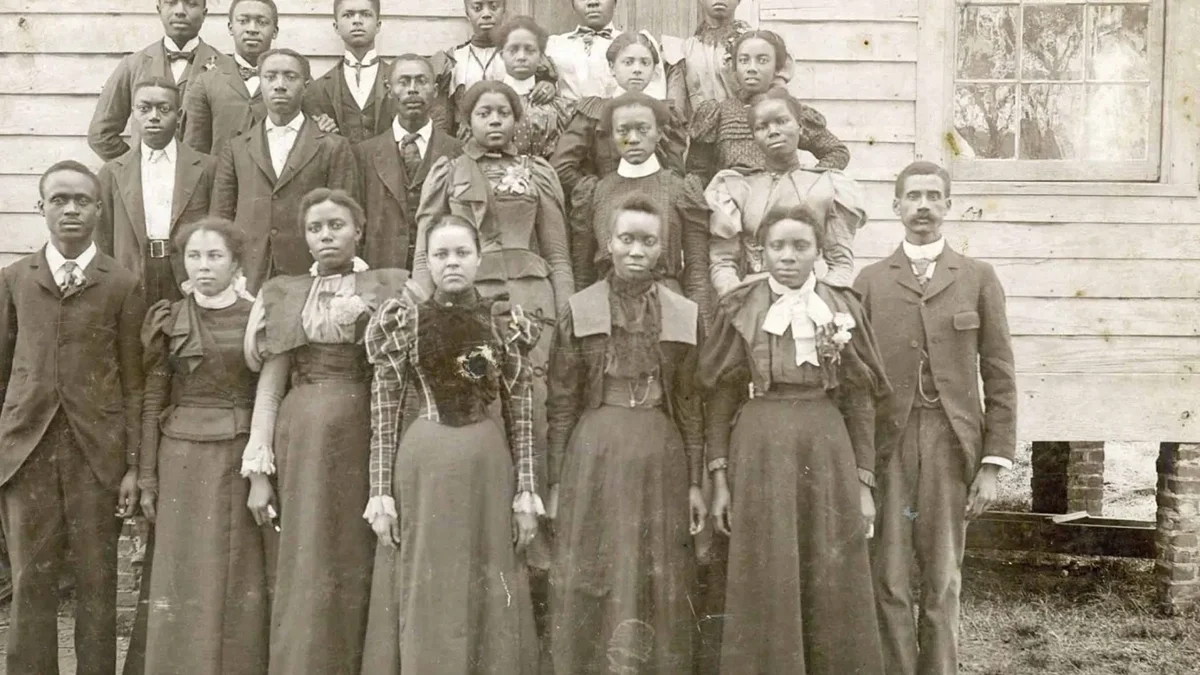 Principal Peter W. Moore, far right, and students of the Elizabeth City State Colored Normal School (later Elizabeth City State University) circa 1894. In the beginning, the school held classes in rented space at the Roanoke Institute, a private school sponsored by a black conference of Missionary Baptists. (Even earlier, a pioneering African American educator, Rooks Turner, had run a common school there.) Later, the State Colored Normal School moved to another temporary locale on what is now Herrington Road in Elizabeth City, then moved to its current home in 1912.