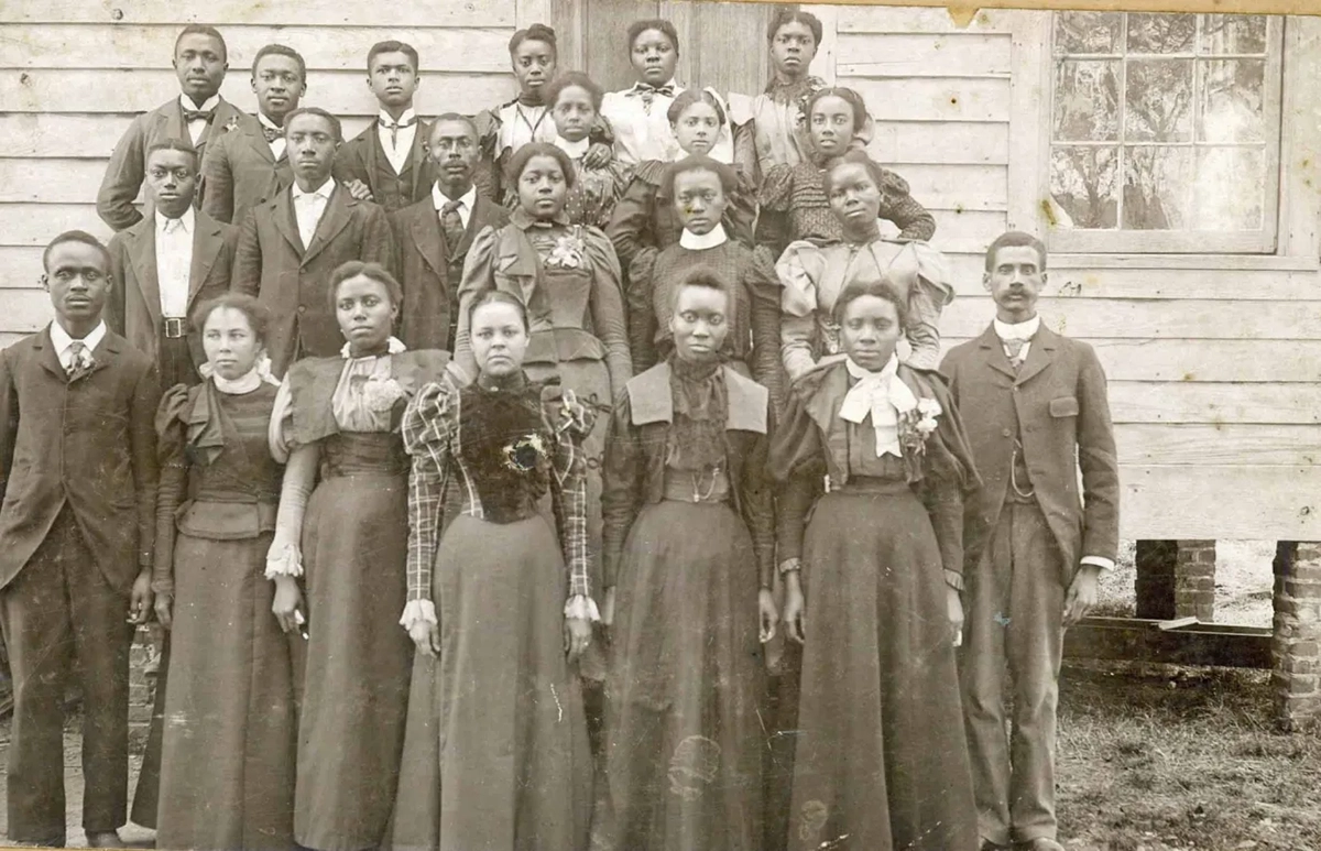 Principal Peter W. Moore, far right, and students of the Elizabeth City State Colored Normal School (later Elizabeth City State University) circa 1894. In the beginning, the school held classes in rented space at the Roanoke Institute, a private school sponsored by a black conference of Missionary Baptists. (Even earlier, a pioneering African American educator, Rooks Turner, had run a common school there.) Later, the State Colored Normal School moved to another temporary locale on what is now Herrington Road in Elizabeth City, then moved to its current home in 1912.