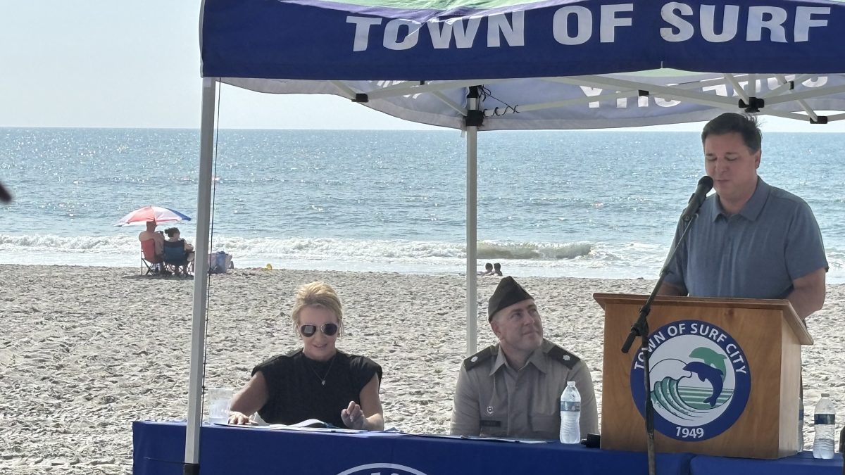 Surf City Mayor Teresa Batts, left, and Corps of Engineers Wilmington District Commander Lt. Col. Kenneth Porter listen as Rep. David Rouzer, R-N.C., speaks Monday during a signing ceremony in Surf City. Photo: Trista Talton