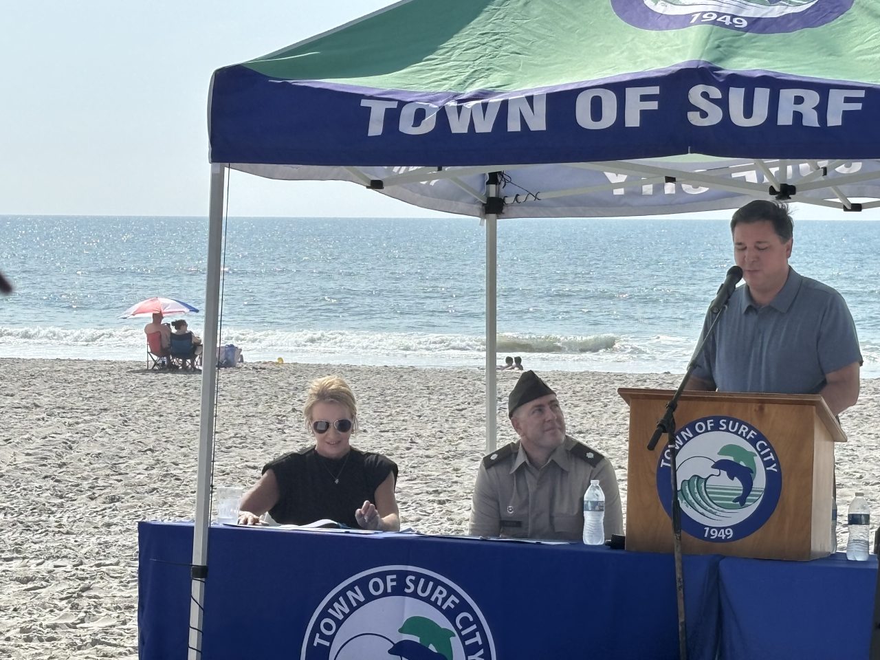 Surf City Mayor Teresa Batts, left, and Corps of Engineers Wilmington District Commander Lt. Col. Kenneth Porter listen as Rep. David Rouzer, R-N.C., speaks Monday during a signing ceremony in Surf City. Photo: Trista Talton