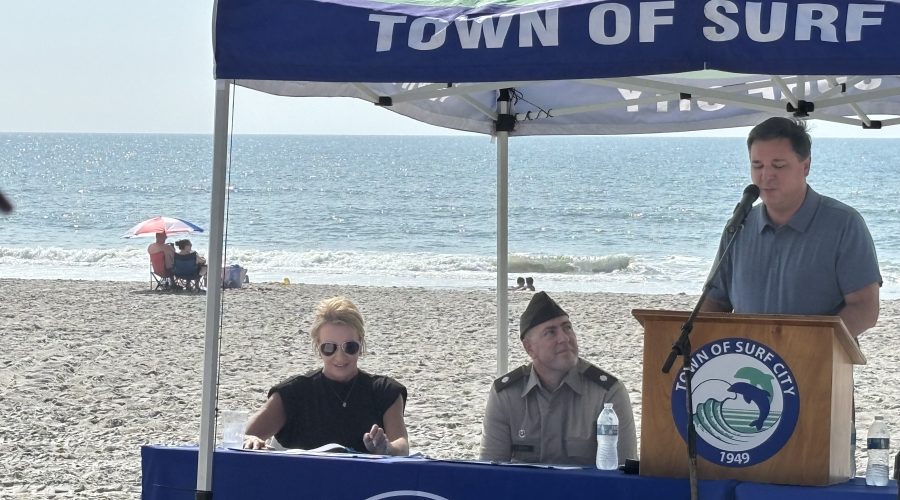 Surf City Mayor Teresa Batts, left, and Corps of Engineers Wilmington District Commander Lt. Col. Kenneth Porter listen as Rep. David Rouzer, R-N.C., speaks Monday during a signing ceremony in Surf City. Photo: Trista Talton