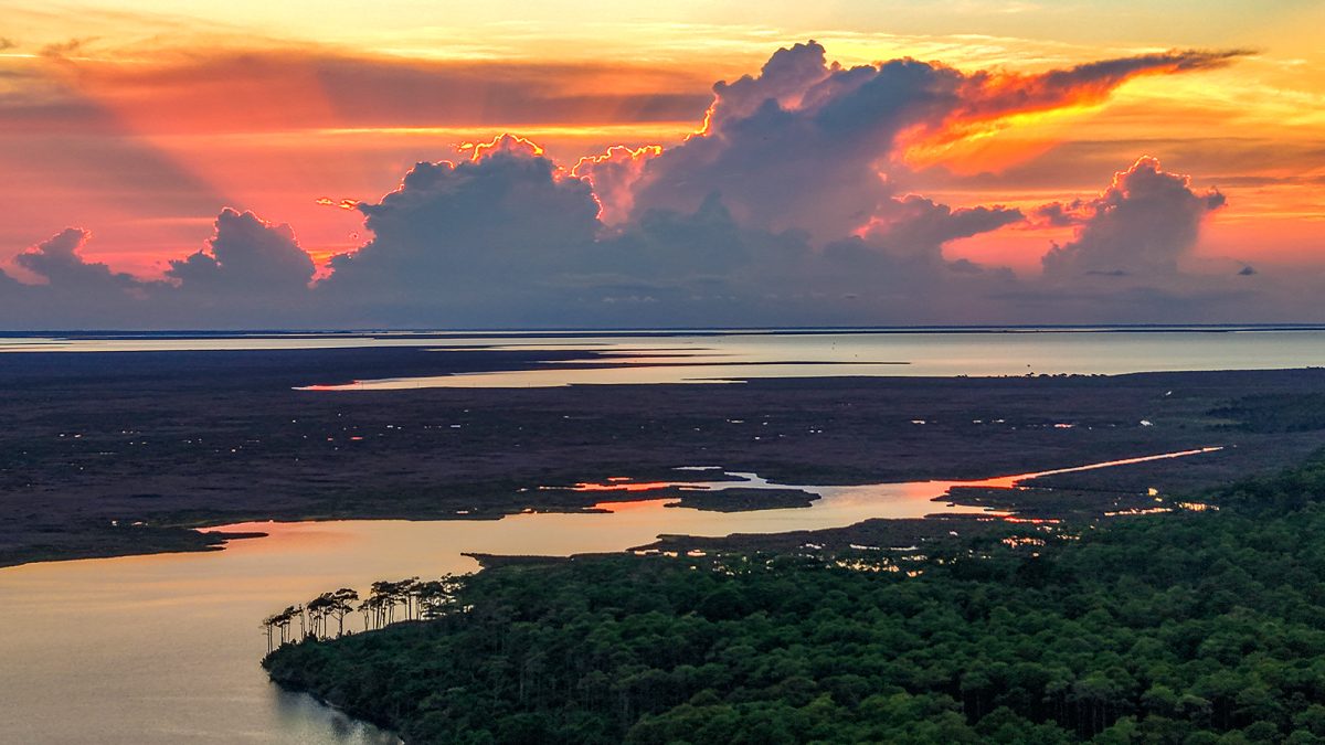 The sun sets behind a cloudbank Saturday as shown from above the Cedar Island National Wildlife Refuge. The refuge off Lola Road on Cedar Island in Carteret County was established in 1964 occupies 14,494 acres on a peninsula jutting into southern Pamlico Sound, with N.C. Highway 12 slicing through and the 5,500-acre Cedar Island National Wildlife Reserve just to the east. The refuge and the reserve both offer opportunities to immerse one's self into nature, such as hiking, paddling, birding and nature viewing, as well as numerous other activities. Photo: Dylan Ray