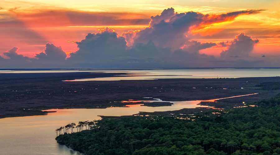 The sun sets behind a cloudbank Saturday as shown from above the Cedar Island National Wildlife Refuge. The refuge off Lola Road on Cedar Island in Carteret County was established in 1964 occupies 14,494 acres on a peninsula jutting into southern Pamlico Sound, with N.C. Highway 12 slicing through and the 5,500-acre Cedar Island National Wildlife Reserve just to the east. The refuge and the reserve both offer opportunities to immerse one's self into nature, such as hiking, paddling, birding and nature viewing, as well as numerous other activities. Photo: Dylan Ray