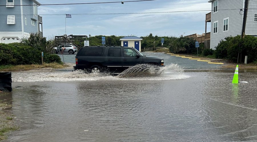A motorist passes through floodwater on South Shore Drive prior to recent stormwater projects. Photo: Surf City