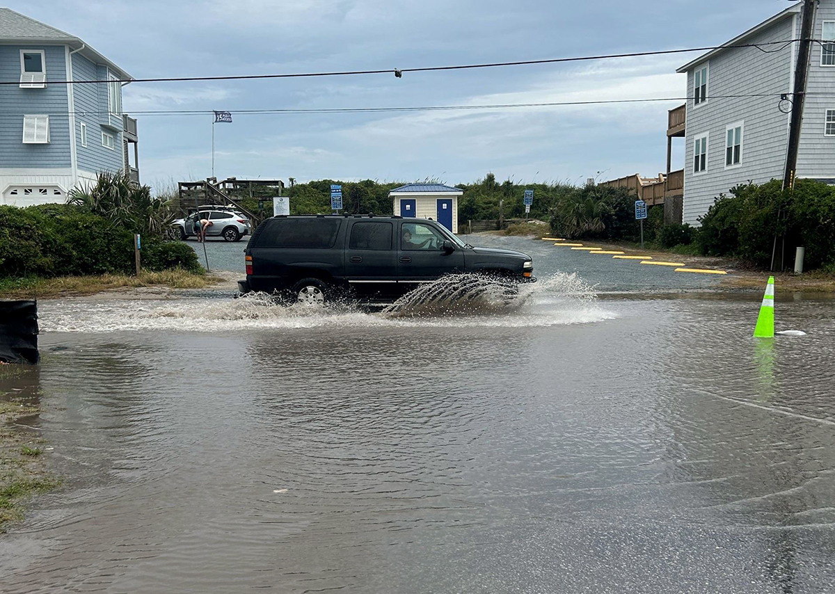 A motorist passes through floodwater on South Shore Drive prior to recent stormwater projects. Photo: Surf City