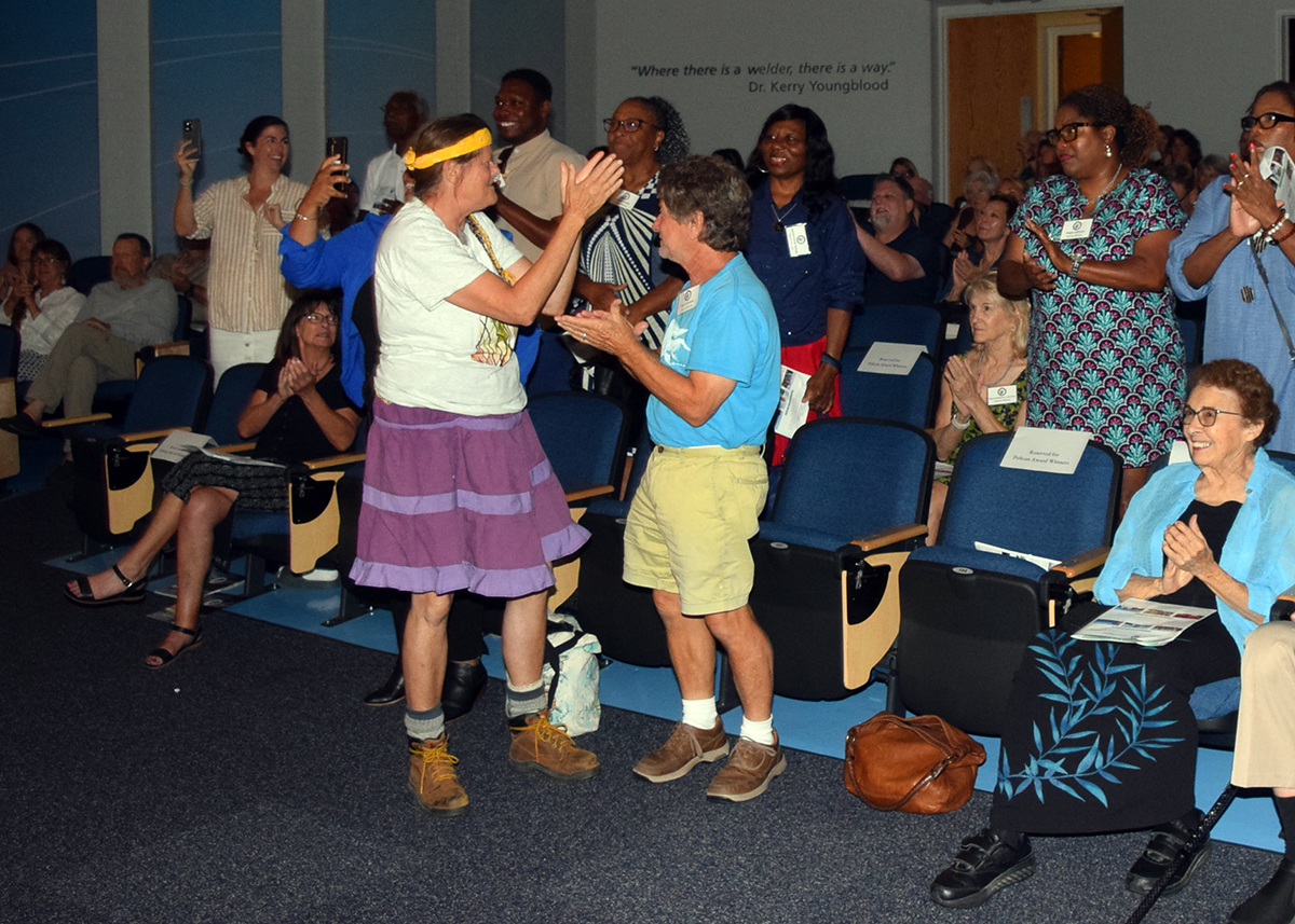 Standing in the front row, Pelican Award winners Nan Bowles, left, and Thomas L. Kirmeyer applaud the North River Laurel Road Ladies Outreach Committee, members of which stand in the second row, that was awarded for “For Grassroots Leadership Advancing Coastal Resilience and Community Action.” Photo: Mark Hibbs