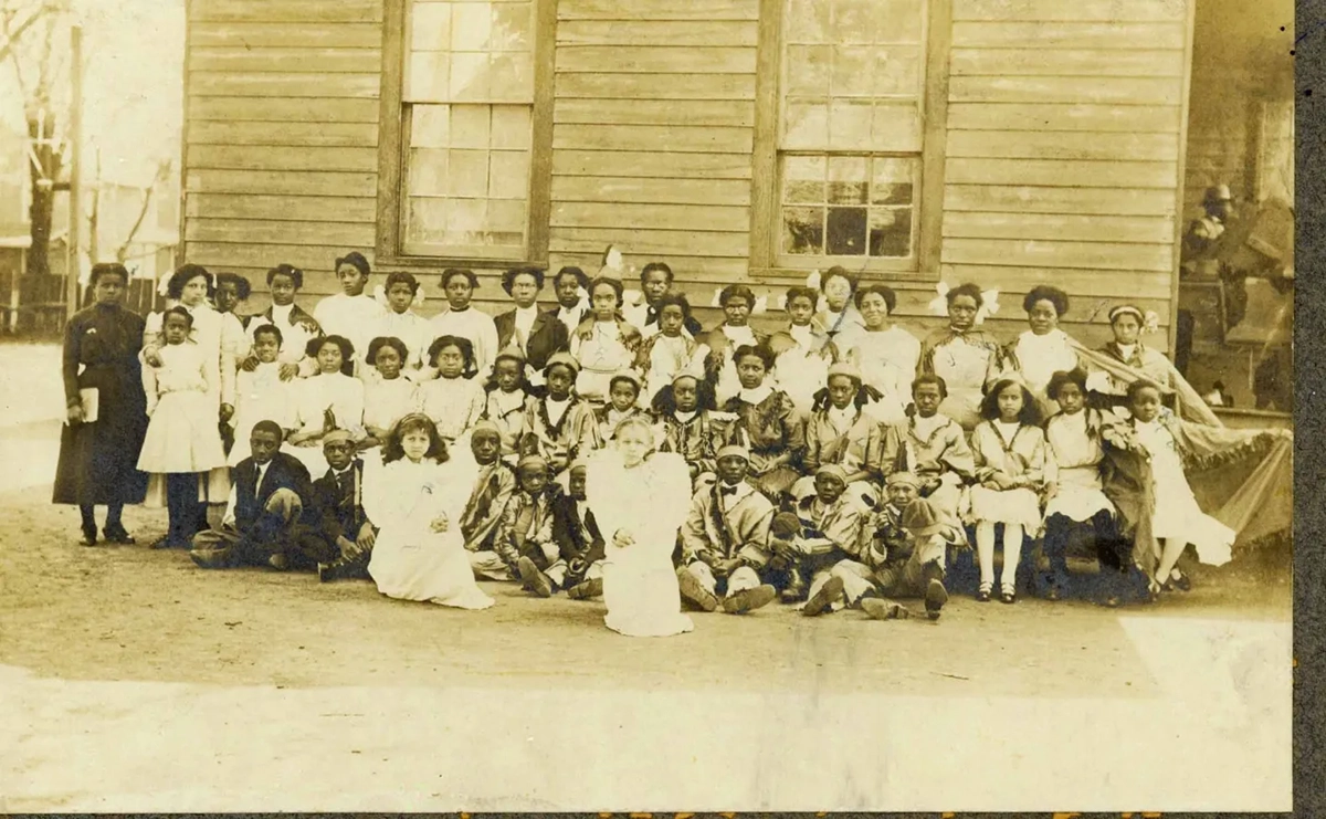 Teachers and children, some in costume, are shown after a Christmas pageant on the grounds of one of the temporary school campuses, sometime prior to the school moving to its current location in 1912. Courtesy, University Archives, Elizabeth City State University