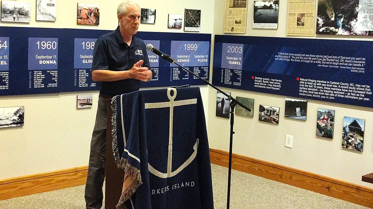 Department of Environmental Quality Secretary Reid Wilson speaks from a podium in an exhibit on Down East Carteret County hurricane history at the Core Sound Waterfowl Museum and Heritage Center Monday on Harkers Island. Photo: Jennifer Allen