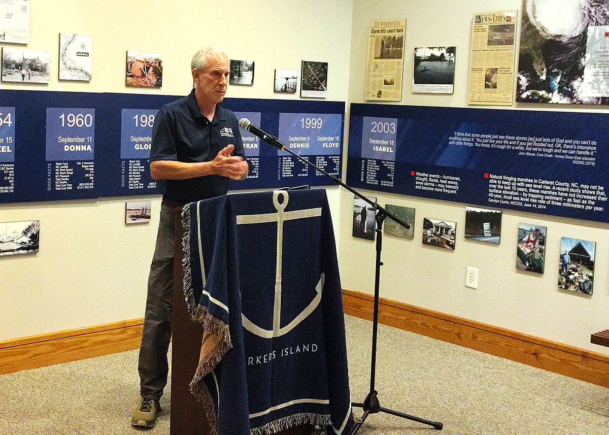 Department of Environmental Quality Secretary Reid Wilson speaks from a podium in an exhibit on Down East Carteret County hurricane history at the Core Sound Waterfowl Museum and Heritage Center Monday on Harkers Island. Photo: Jennifer Allen