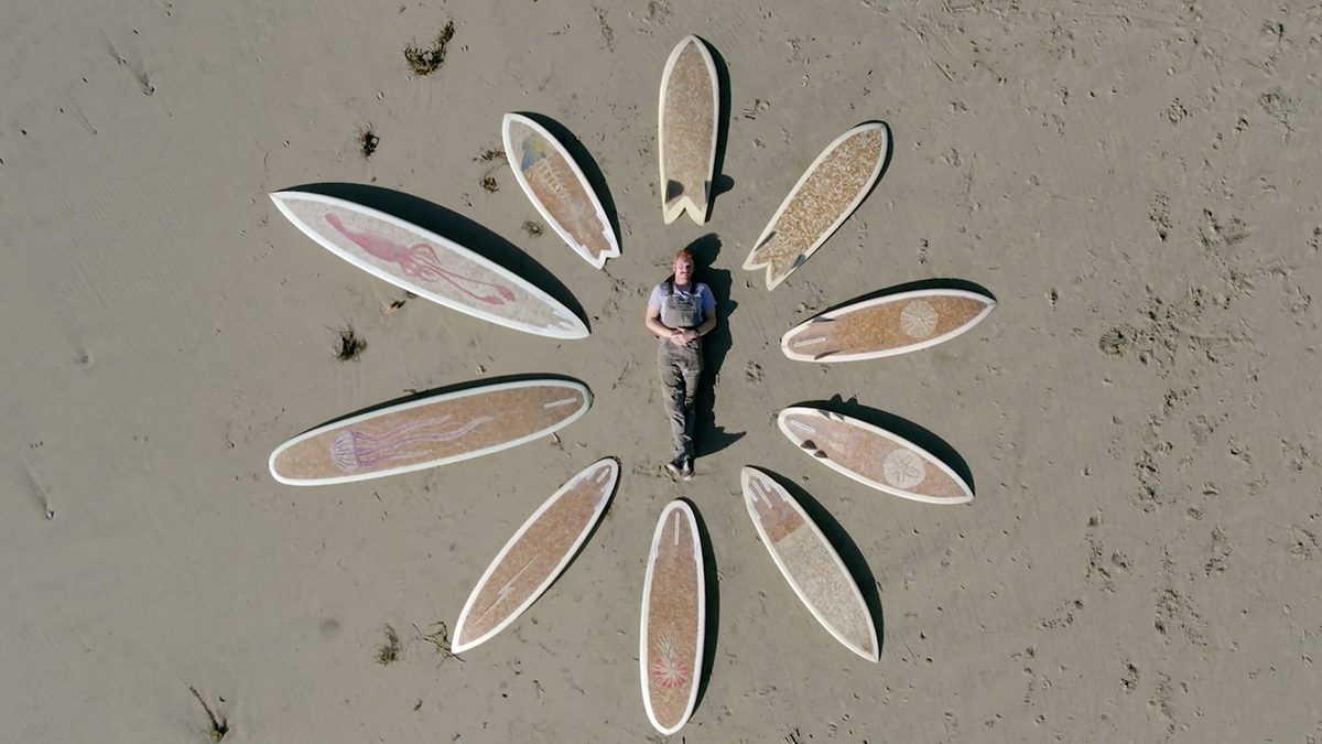 Film coproducer Taylor Lane poses with the 10 cigarette surfboards he created. Photo contributed.